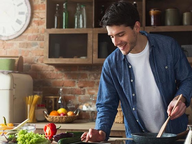 man aan het koken in keuken