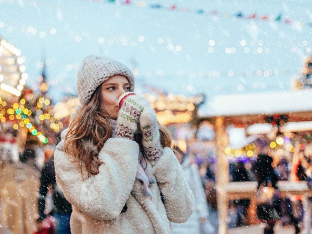 Vrouw chocolademelk kerstmarkt