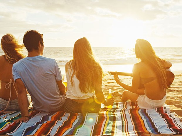 Een vriendengroepje aan het strand, kijkend naar de zee