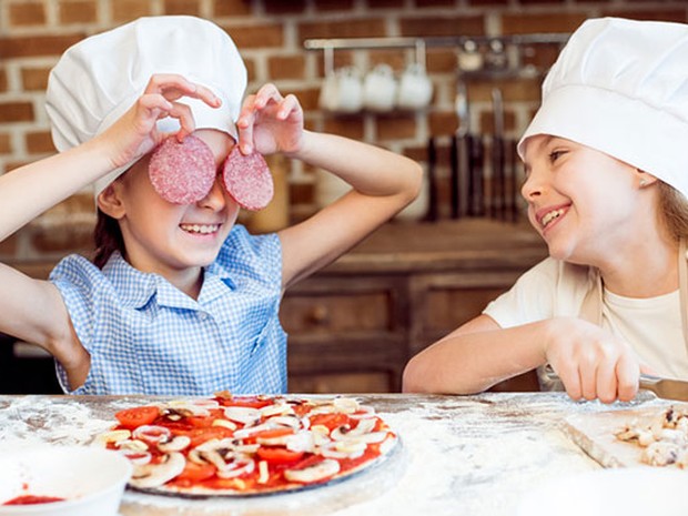 kinderen pizza maken koksmuts salami champignons meel