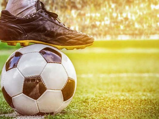 Voetbalschoen op een voetbal