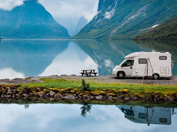 Camper bij bergen en meer