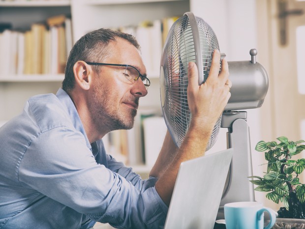 Man houdt ventilator voor zijn gezicht