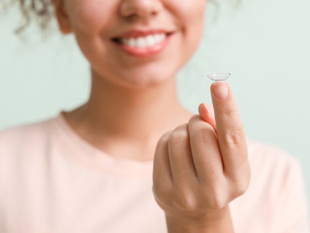 vrouw met contactlens op vinger