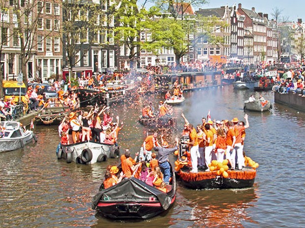 Amsterdamse gracht met bootjes tijdens Koningsdag