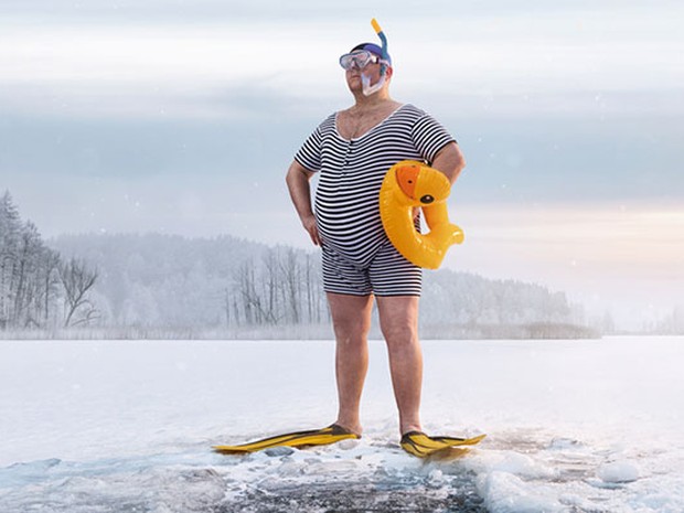 man neemt ijsbad in gekke outfit