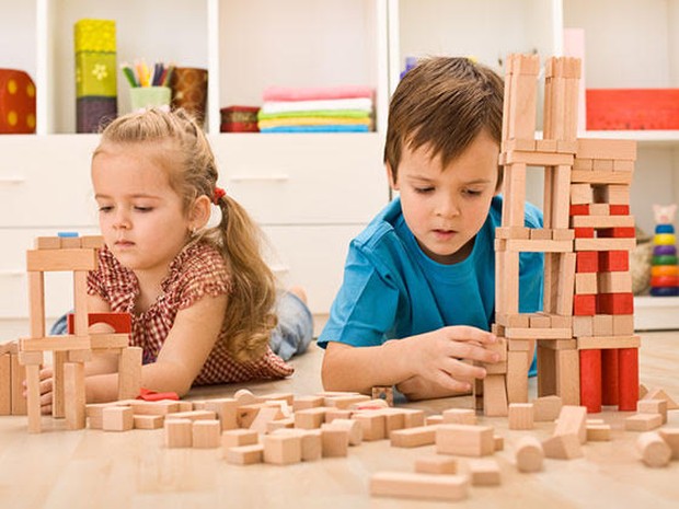 Twee kinderen die op de grond met blokken spelen