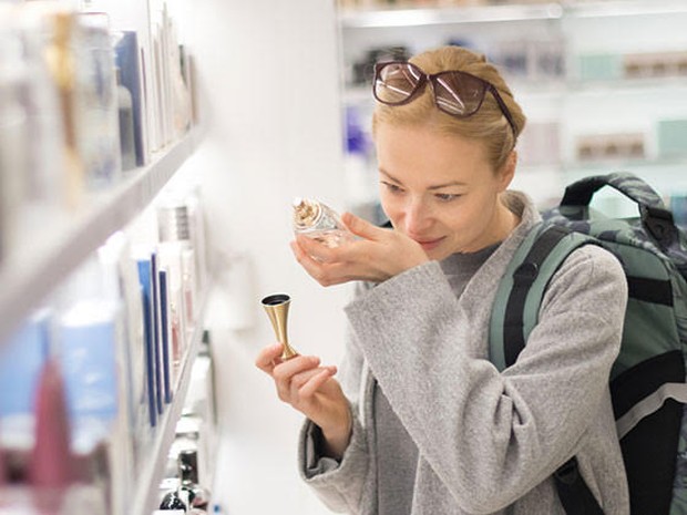 Een vrouw die in een winkel een luchtje uitprobeert