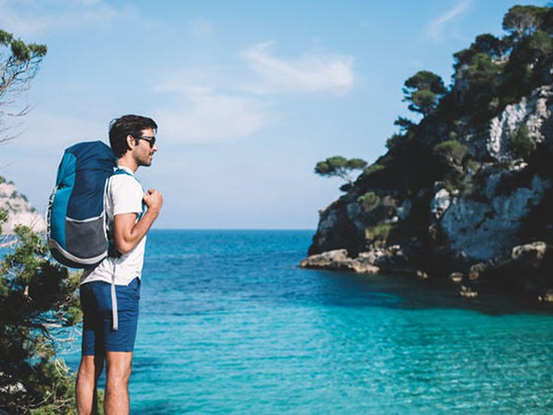 Een backpacker genietend van het uitzicht aan zee