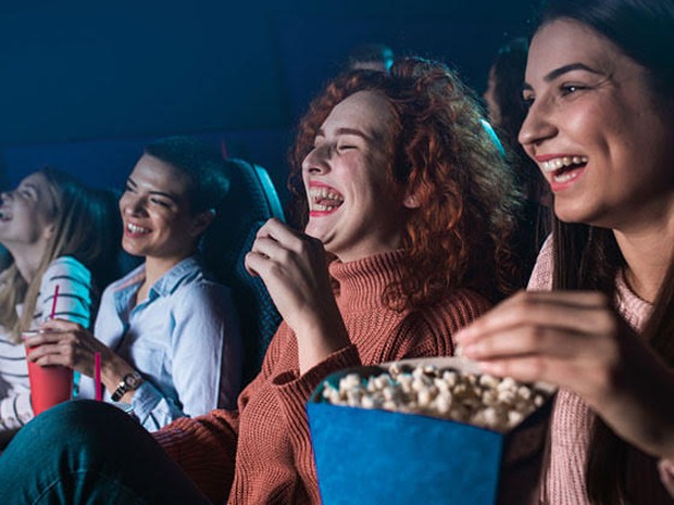Lachend publiek in de bioscoop met popcorn