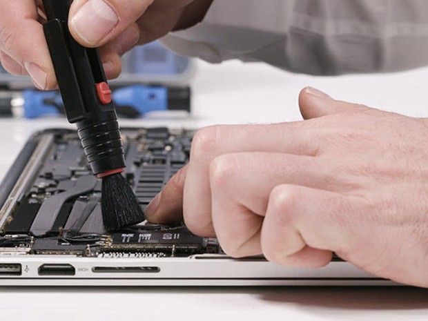 Iemand die een laptop schoonmaakt en repareert