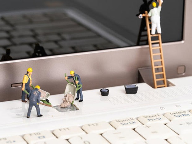 Miniatuur mannetjes die aan het onderhoud van een computer werken