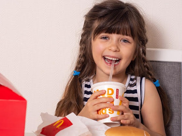 Een meisje genietend van haar Happy Meal