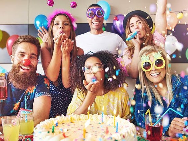 Vrienden vieren verjaardag met taart en ballonnen
