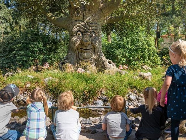 Kinderen zittend voor de Babbelboom in het Sprookjesbos van de Efteling