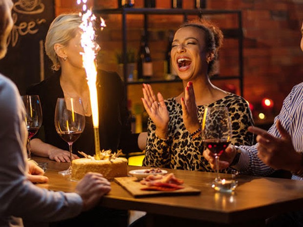 Een groep die een verjaardag viert met vuurwerk op een taart