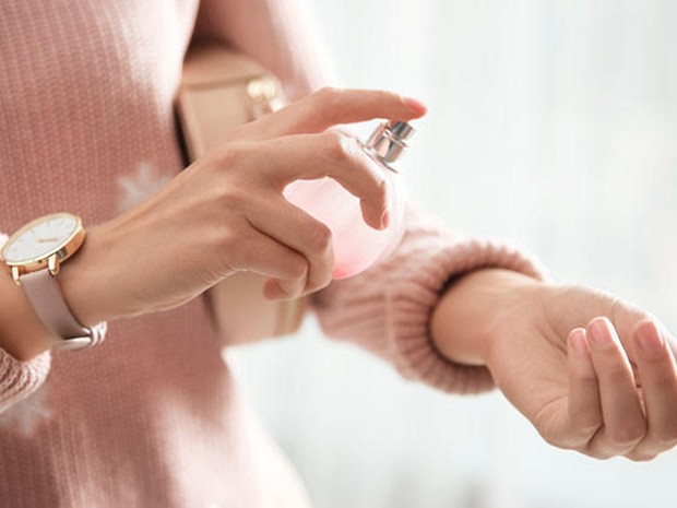 Een vrouw die een geurtje opdoet bij haar pols